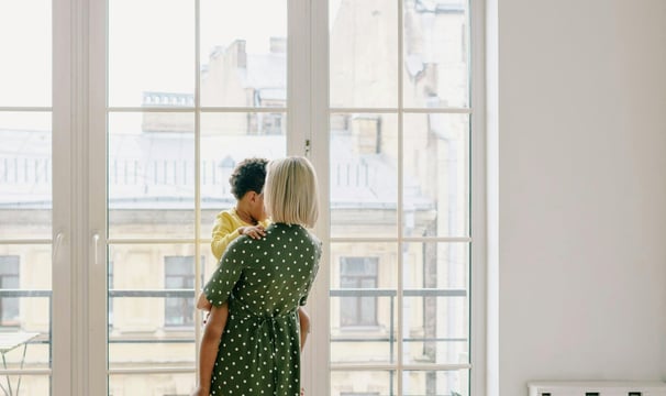 a woman in a green dress holding a baby