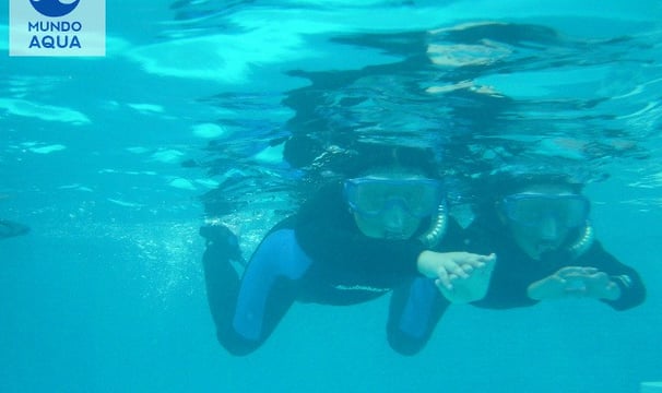 a boy and girl in scuba gear in the water