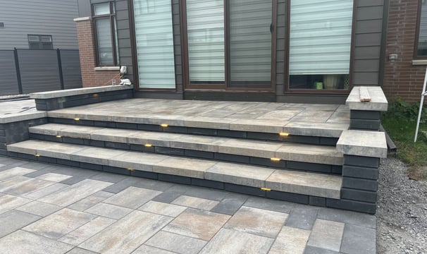 a patio with a brick patio and steps leading up to a patio