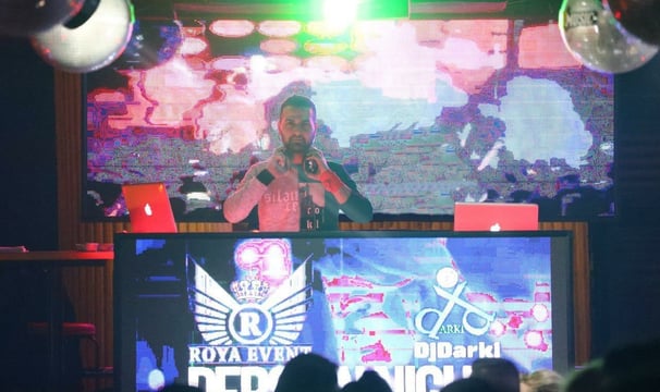 a man standing in front of a large screen with a microphone