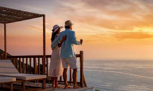 a couple of people standing on a deck overlooking the ocean