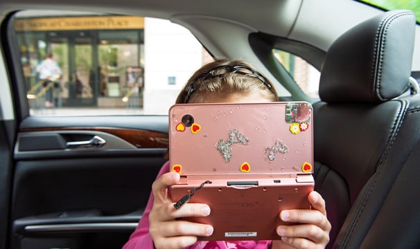 a young girl holding a pink camera in her hands