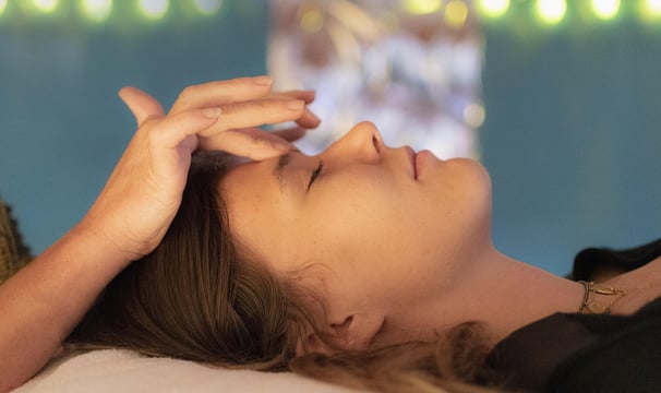 Illustration of a craniosacral reflexology session, the patrician's fingers are placed on the eyebro