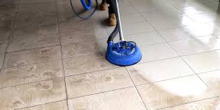 a person cleaning a tile floor with a vacuum