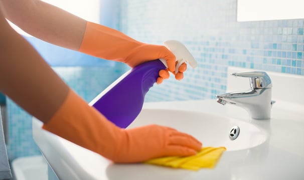 a person in gloves and gloves cleaning a sink