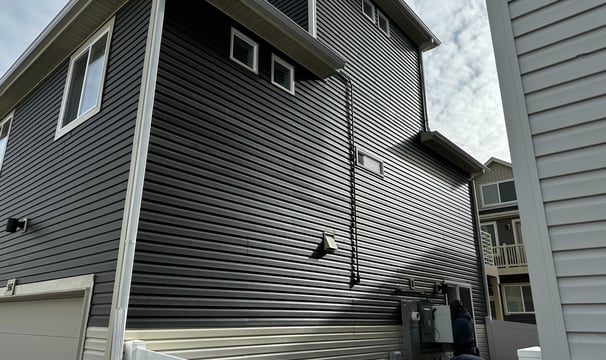 a house with a white fence and vinyl siding