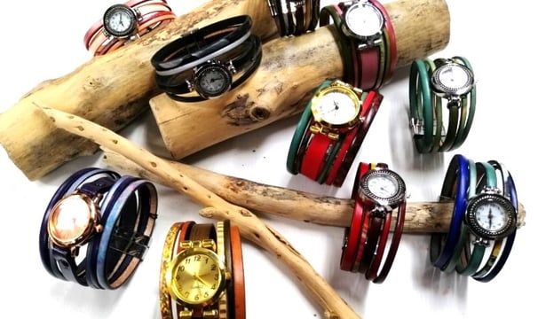 a bunch of bracelets and watches on a stick