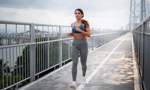 Full shot fit woman running outdoors.