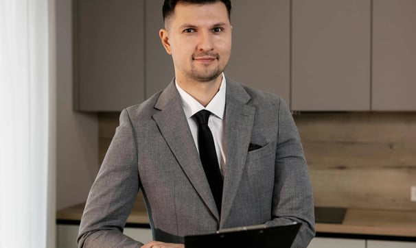 un hombre con traje y corbata de pie en una cocina