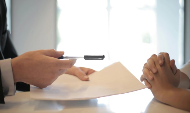 un hombre y una mujer sentados a una mesa con papeles