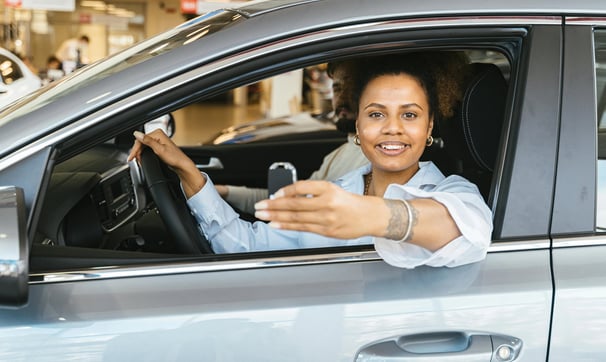 una mujer en un coche con un móvil en la mano