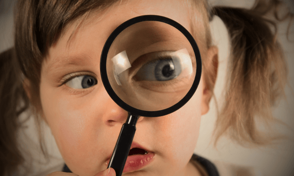 Criança observando curiosa pela lente o mundo: