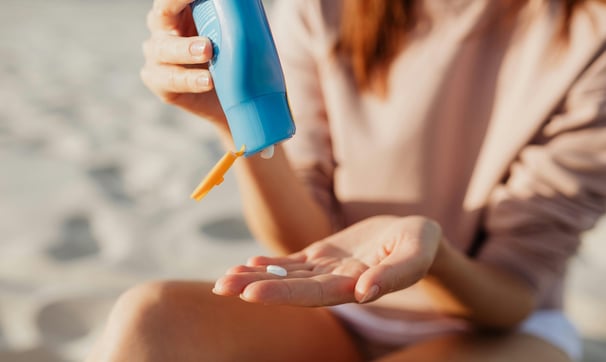 Woman applying sunblock by the beach