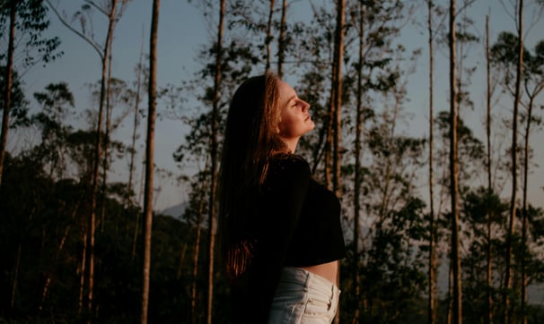 A woman spending some time amongst the trees in the forest