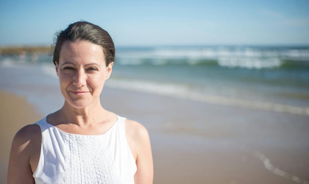 A happy woman by the beach dressed in white