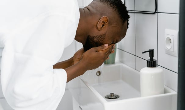 A man cleansing his face as part of his skincare routine