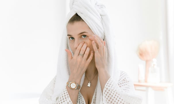 A woman applying eye cream