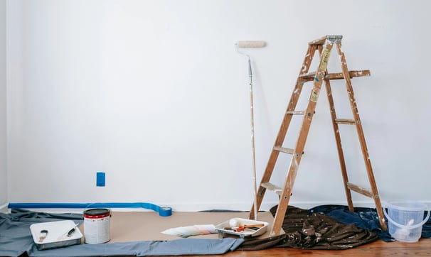 una escalera con pintura y un rodillo de pintura