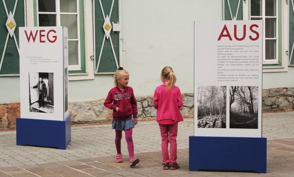 Besucher erkunden die Außenanlage der mobilen Ausstellung "Aus weg los!".