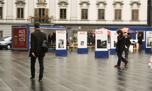 Menschen gehen durch die Ausstellung "Aus weg los!" auf der Grazer Hauptplatz.