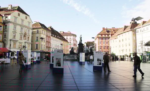 Menschen gehen durch die Ausstellung "Aus weg los!" auf der Grazer Hauptplatz.