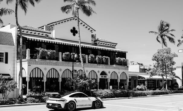 a porsche passing by a hotel on 5th avenue in naples florida