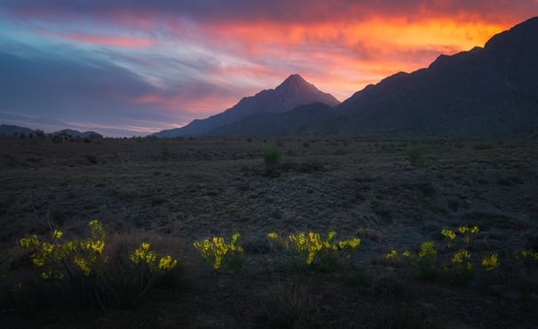 a sunset sky with a mountain in the background. arbab naimat kasi balochistan