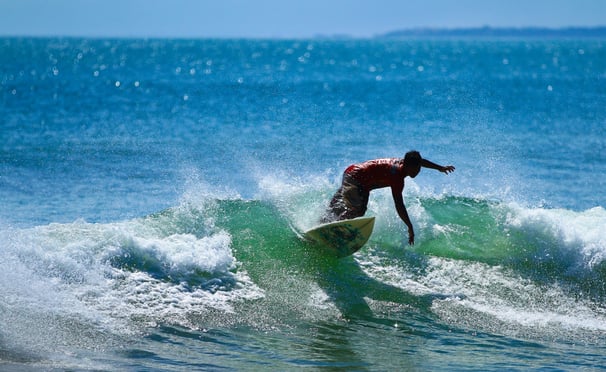 Um surfista na praia de Kuta, em Bali - Por Jordy Meow (Wikipédia)