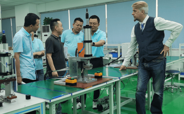 a man standing in a factory with a machine