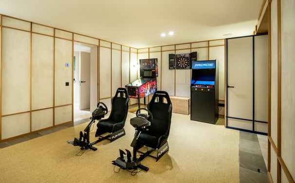 Game room at Villa La Gratitud with PlayStation simulators, pinball, arcade, and darts.
