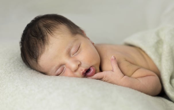 Sessió de fotos newborn a Girona amb una bebè recent nascuda dormint en estudi fotogràfic