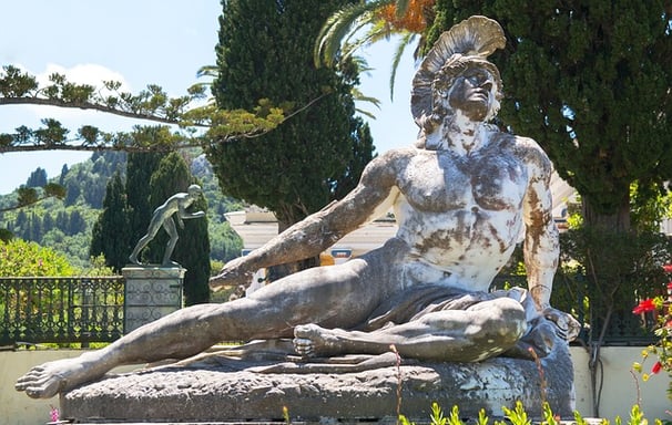 a statue of a man sitting on a stone steps