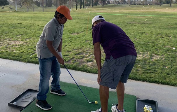 Enhancing Forward Action Inc. image young golfer being taught golf