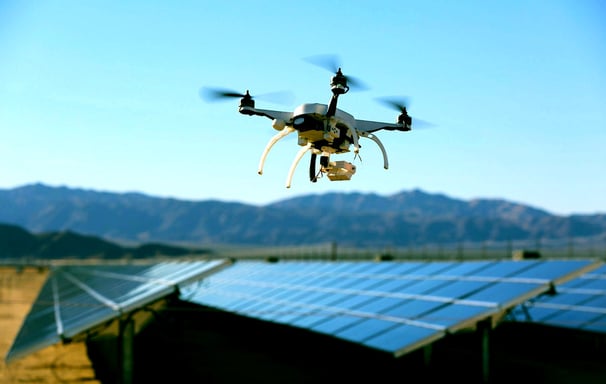 a drone flying over a solar paneled roof