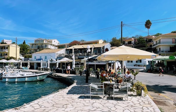 a group of people sitting at tables near a dock