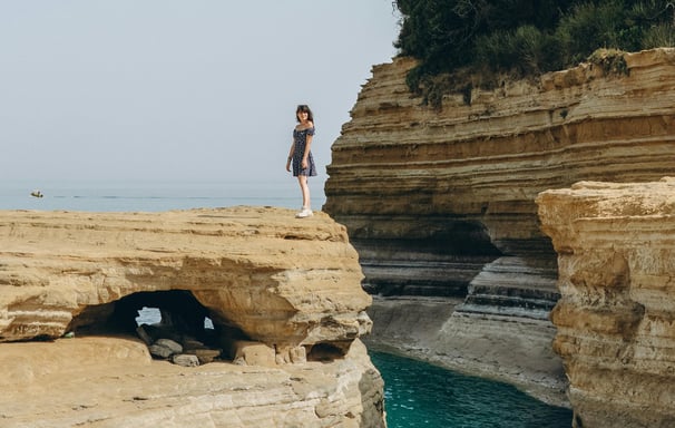 a woman standing on a cliff overlooking the ocean
