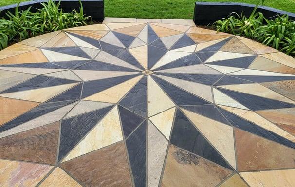Sandstone paving with sleepers and agapanthus plants