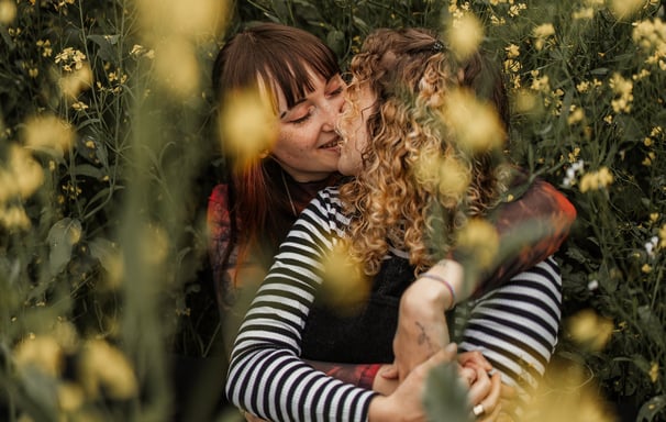 Lesbisches Paar küsst sich im Gras