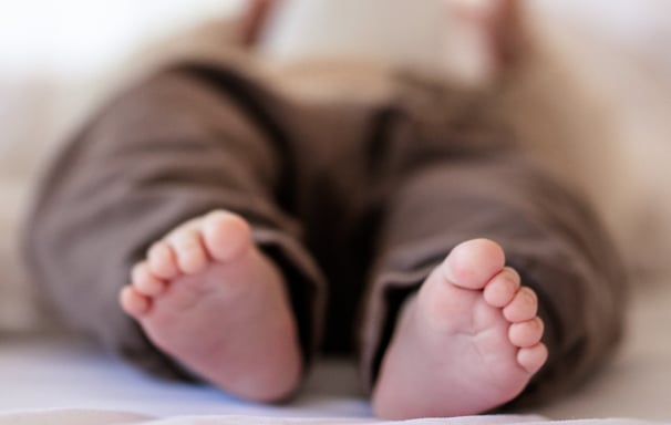Baby Füße auf dem Bett mit Spielzeug-Hase