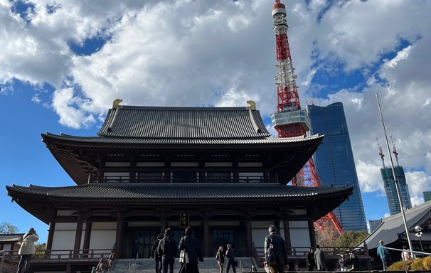 a large building with stairs and a tower in the background
