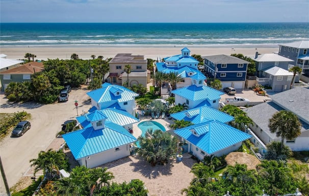 a beachfront home with blue roofing and blue roofing