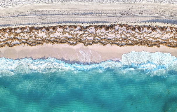 a beach scene with a surfboarder and a surfboard
