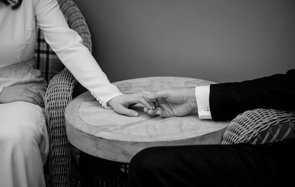 Black and White wedding photo of bride and groom holding hands