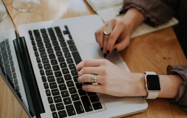 a hand typing on a modern laptop