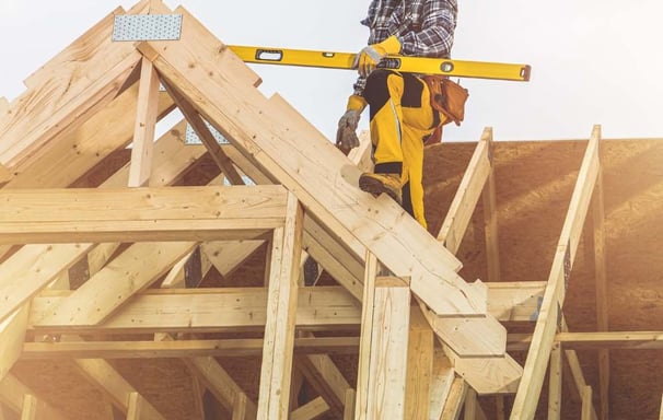 a construction worker on a roof top with a level level of construction