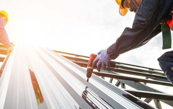 two workers working on a roof top of a building