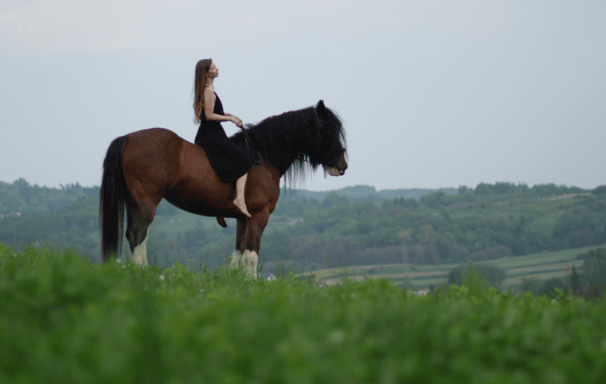 Kasia Bukowska riding her shire horse bareback and bitless on a trail overlooking Dubiecko