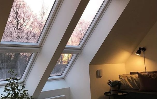 Technicien professionnel nettoyant une fenêtre de toit Velux avec des outils spécialisés