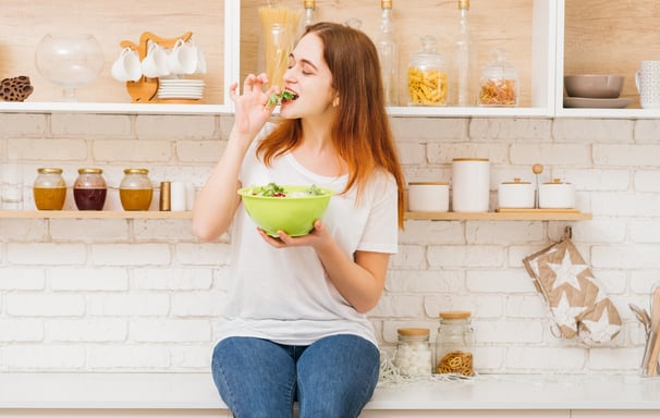 a woman sitting on a counter with a bowl of food