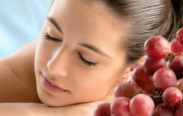 a woman with her hands on her chest and a bunch of grapes